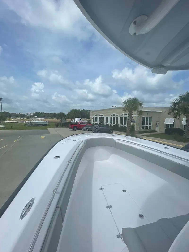 Slide: The Image of 2024 Cape Horn 31T boat with spacious deck, docked near a building under a cloudy sky. - 6