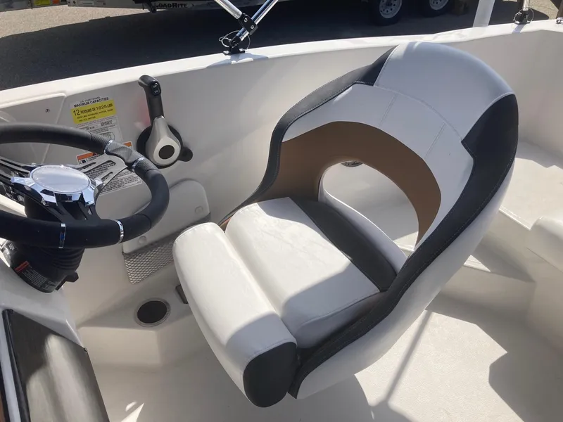 Slide: The Image of 2024 Starcraft SVX 191 boat cockpit with steering wheel and captain's chair. - 4
