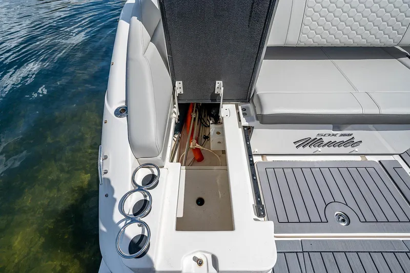 Slide: The Image of 2021 Sea Ray 25 SDX boat with open storage compartment and seating area. - 11