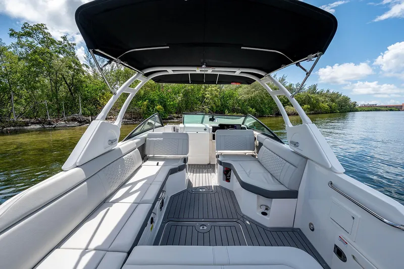 Slide: The Image of 2021 Sea Ray 25 SDX boat with spacious seating and canopy on a serene waterway. - 6