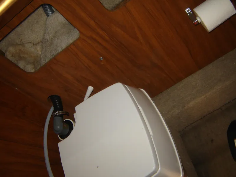 Slide: The Image of Boat bathroom interior with toilet, wooden paneling, and carpeted floor in a 1980 Century 26 model. - 32
