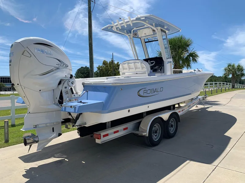 Slide: The Image of 2024 Robalo 266 Cayman boat on a trailer, featuring a powerful outboard motor. - 1