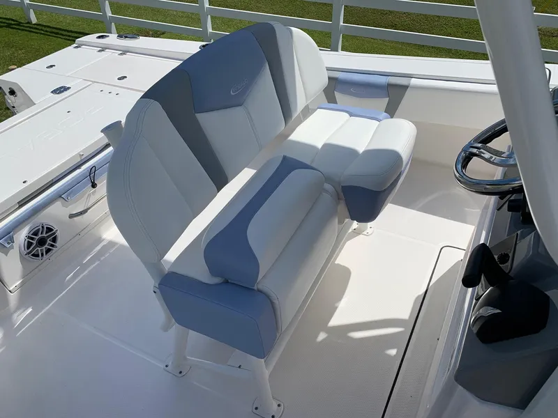 Slide: The Image of 2024 Robalo 266 Cayman boat seating area with white and gray cushioned seats. - 13