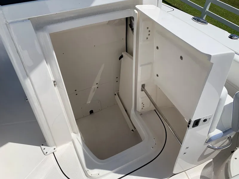 Slide: The Image of 2024 Robalo 266 Cayman storage compartment with open hatch. - 15