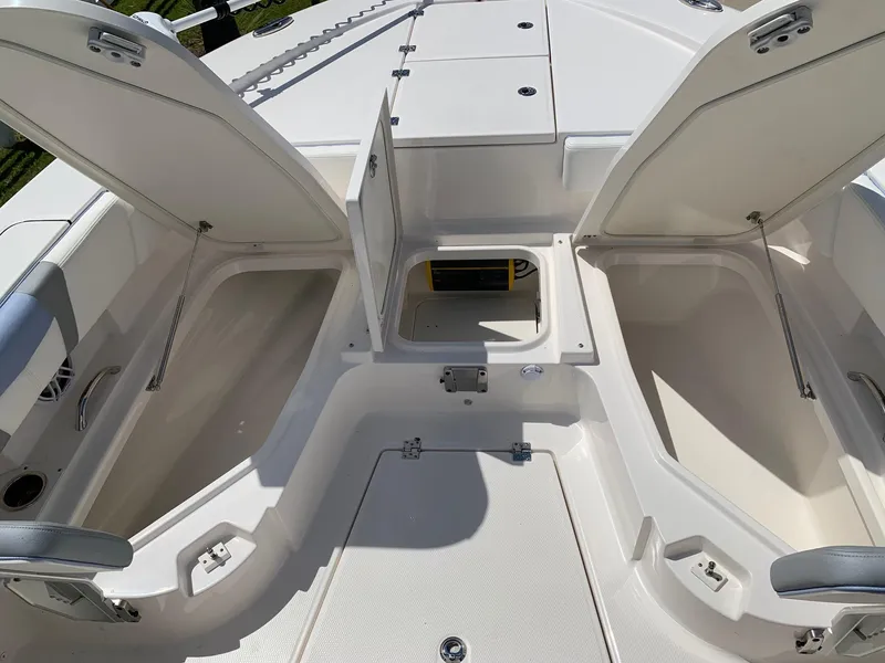 Slide: The Image of 2024 Robalo 266 Cayman boat storage compartments open on deck. - 19