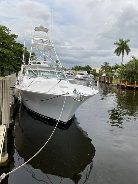 The Image of 2003 Viking 50 Open yacht docked in a serene canal with palm trees. - 0