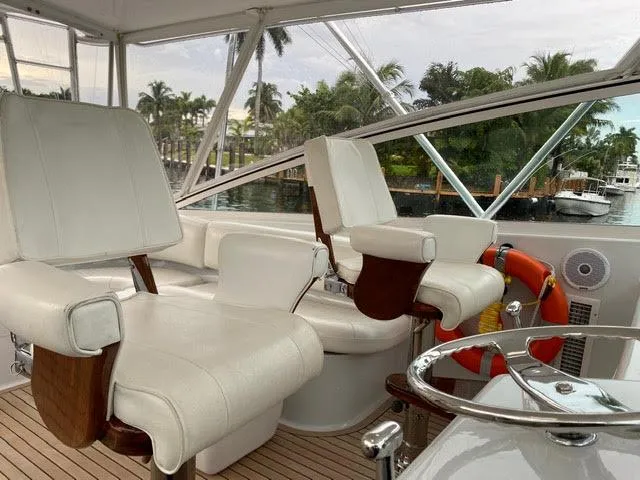 Slide: The Image of 2003 Viking 50 Open yacht helm with white leather seats and waterfront view. - 10