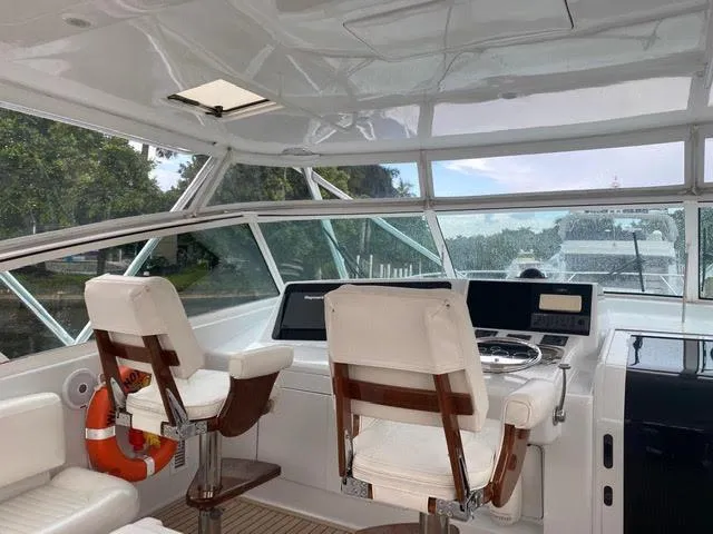 Slide: The Image of 2003 Viking 50 Open yacht helm with white captain chairs and navigation equipment. - 11