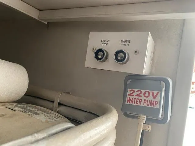 Slide: The Image of Engine start and stop buttons with 220V water pump switch on a 2003 Viking 50 Open boat. - 25