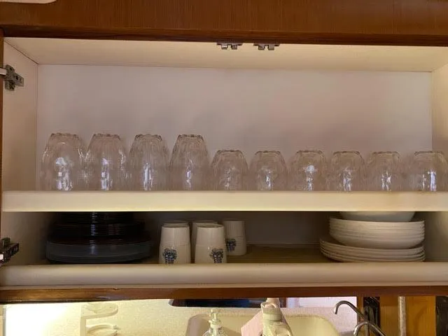 Slide: The Image of Kitchen cabinet with neatly arranged glassware and dishes on a 2003 Viking 50 Open yacht. - 33