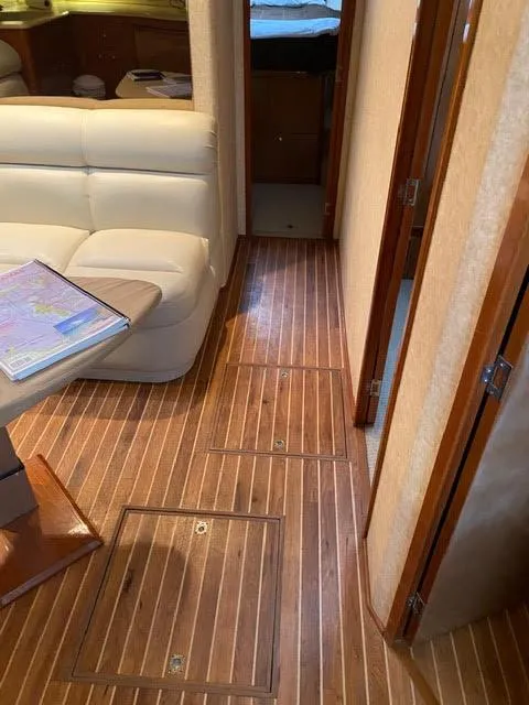Slide: The Image of Interior of a 2003 Viking 50 Open yacht with wooden flooring and beige seating. - 36
