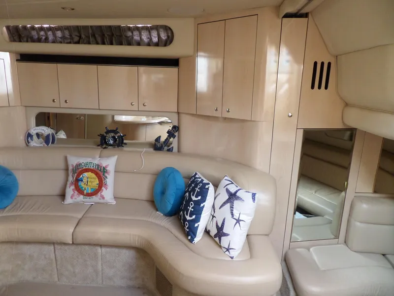 Slide: The Image of Interior of a 2003 Sea Ray 380 Sundancer with beige upholstery and nautical-themed pillows. - 25