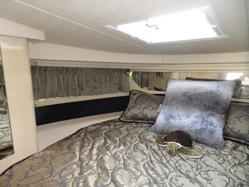 Slide: The Image of Cabin of the 2003 Sea Ray 380 Sundancer with a luxurious bed and skylight. - 44