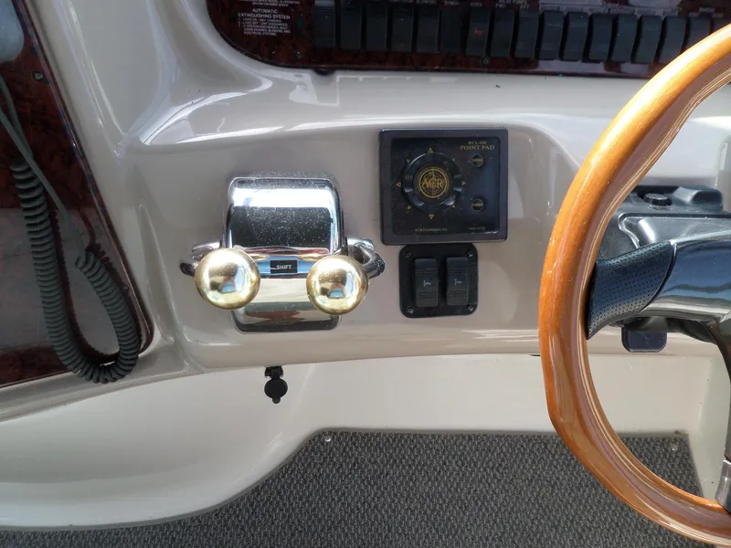 Slide: The Image of Helm of the 2003 Sea Ray 380 Sundancer with wooden steering wheel and throttle controls. - 13