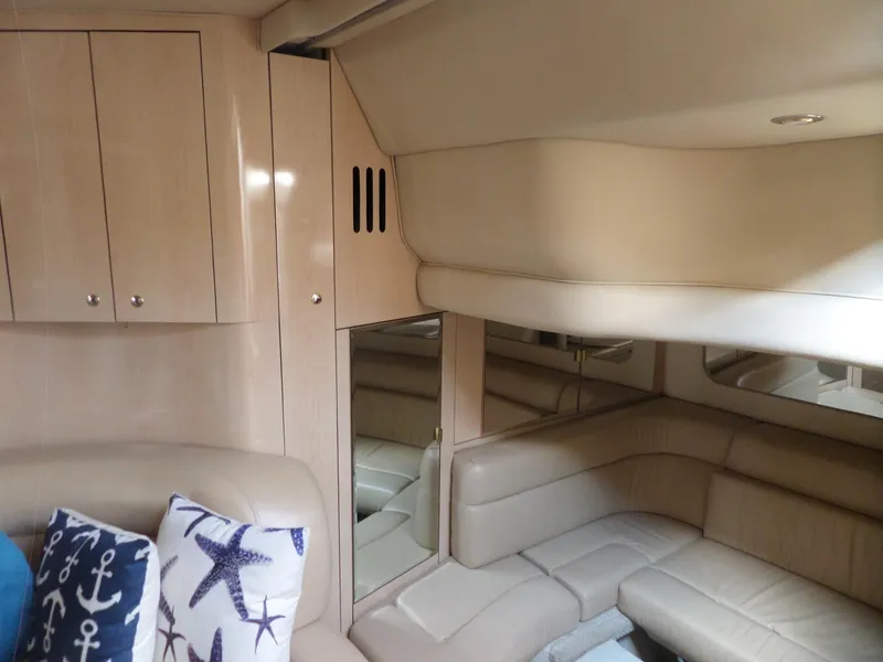 Slide: The Image of Interior of the 2003 Sea Ray 380 Sundancer with beige leather seating and nautical-themed pillows. - 26