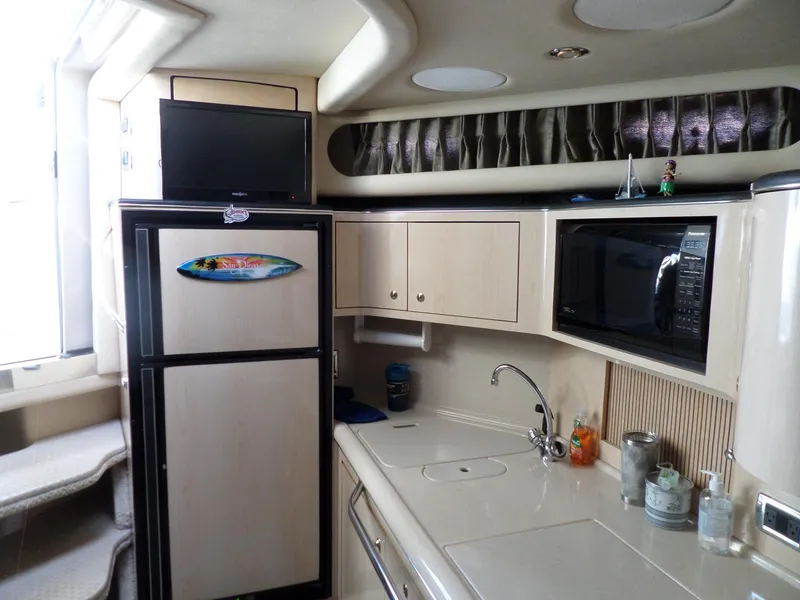 Slide: The Image of Interior of the 2003 Sea Ray 380 Sundancer with kitchen, fridge, and microwave. - 29