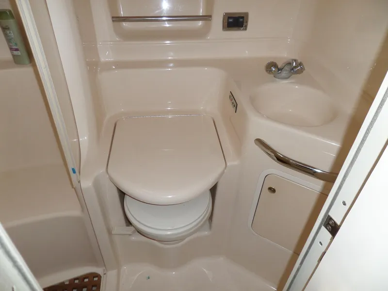 Slide: The Image of The image shows a compact boat bathroom with a toilet, sink, and storage space. - 52