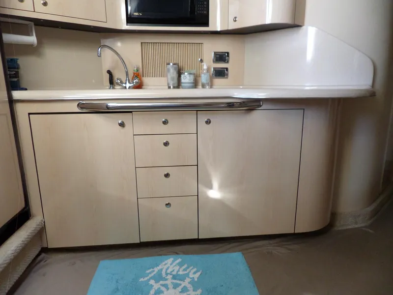 Slide: The Image of The galley of a 2003 Sea Ray 380 Sundancer with light wood cabinetry and a sink. - 40