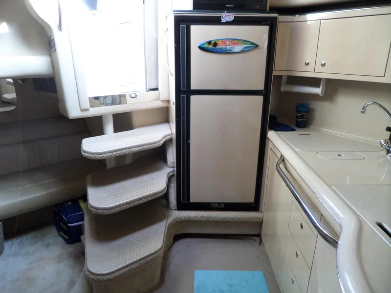 Slide: The Image of Interior of the 2003 Sea Ray 380 Sundancer with stairs, refrigerator, and kitchenette. - 28