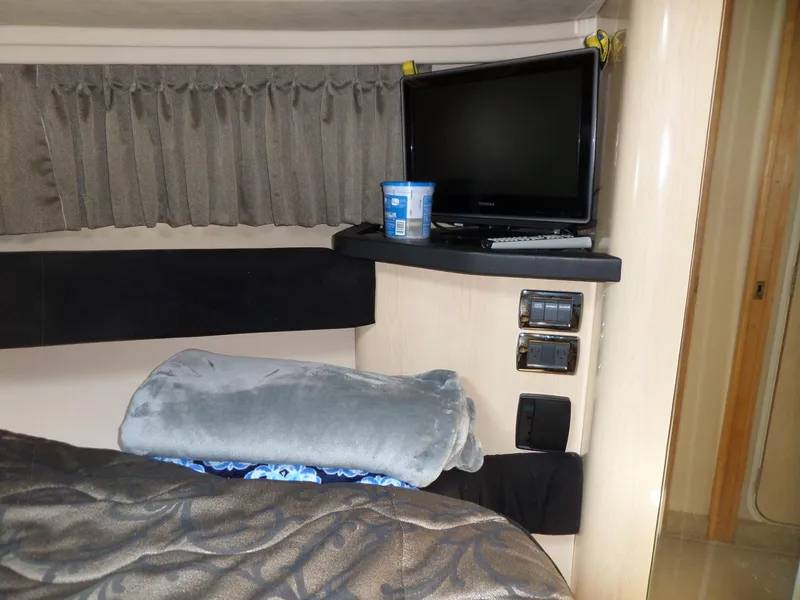 Slide: The Image of Interior of the 2003 Sea Ray 380 Sundancer with a TV and gray blanket. - 47