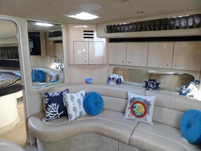 Slide: The Image of Interior of the 2003 Sea Ray 380 Sundancer with curved sofa and nautical decorations. - 49