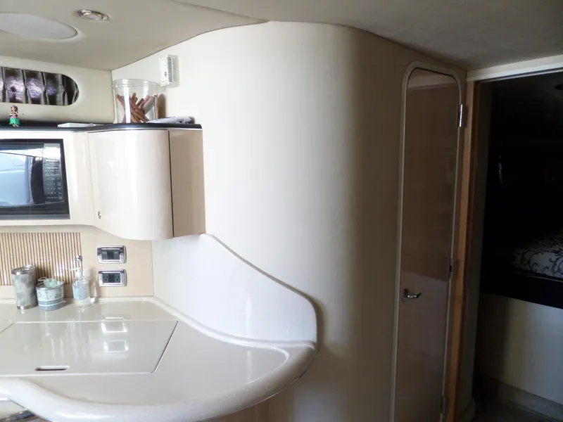 Slide: The Image of Interior of a 2003 Sea Ray 380 Sundancer with sleek kitchen and curved cabinetry. - 32