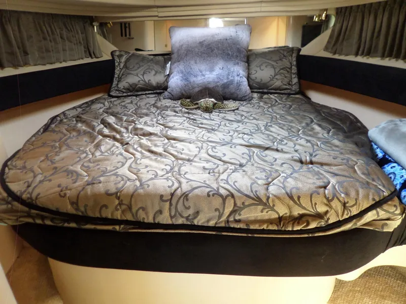 Slide: The Image of Cabin of the 2003 Sea Ray 380 Sundancer with a large, elegantly patterned bed and pillows. - 55