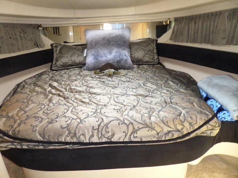 Slide: The Image of The cabin of the 2003 Sea Ray 380 Sundancer features a luxurious bed with patterned pillows. - 45