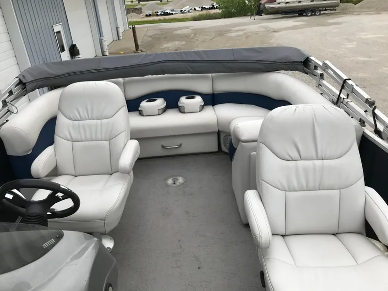 Slide: The Image of 2015 Palm Beach Ultra Sport 220 boat interior with white seating and steering wheel. - 14