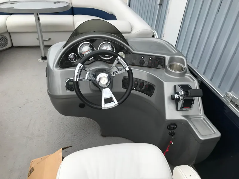 Slide: The Image of 2015 Palm Beach Ultra Sport 220 boat dashboard with steering wheel and controls. - 18