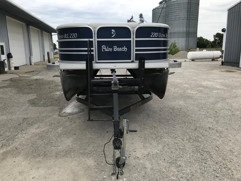 Slide: The Image of 2015 Palm Beach Ultra Sport 220 pontoon boat on trailer in industrial setting. - 9