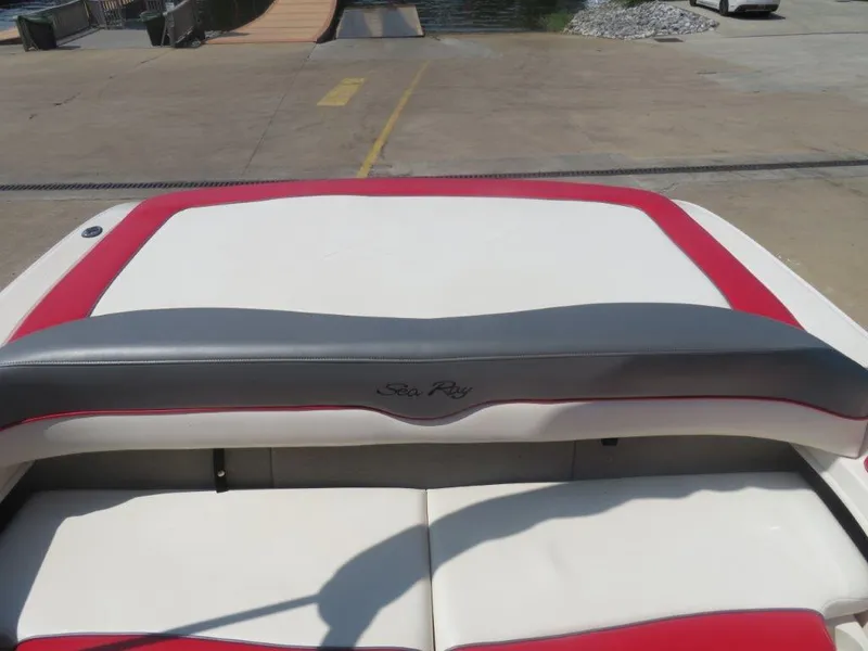 Slide: The Image of 2006 Sea Ray 205 Sport boat interior with red and white seating at a dock. - 2