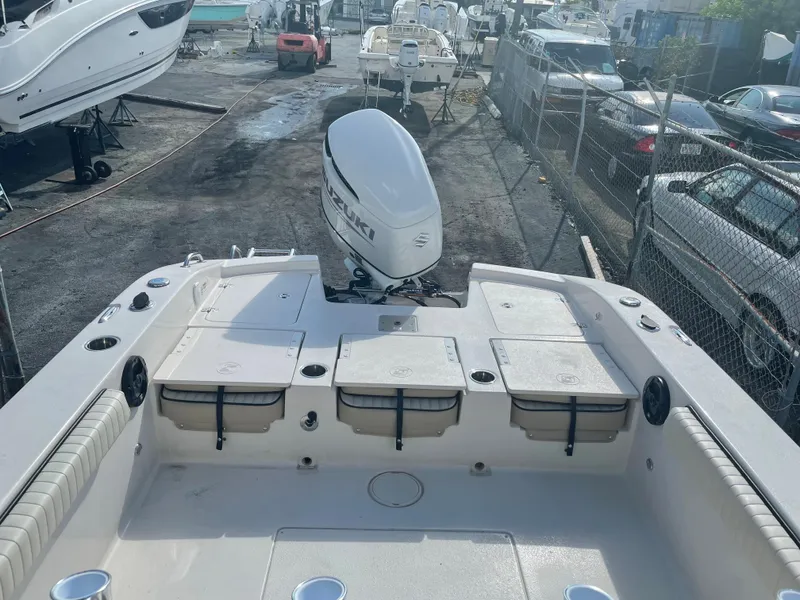 Slide: The Image of 2024 Carolina Skiff 26 Ultra Elite boat with outboard motor, docked in a marina. - 19