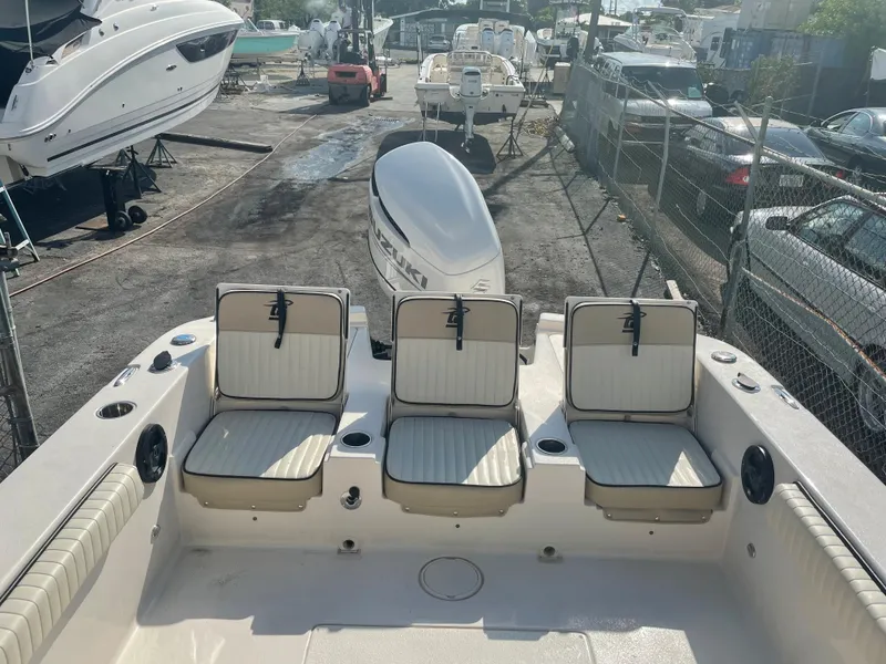Slide: The Image of 2024 Carolina Skiff 26 Ultra Elite boat with seating and outboard motor in a marina. - 20