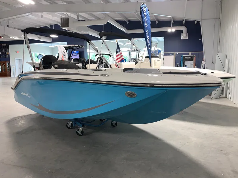 Slide: The Image of 2024 Bayliner Element M17 boat in showroom, blue hull, black canopy. - 2