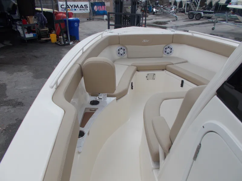 Slide: The Image of 2025 Scout 240 XSF boat interior with beige seating and cup holders. - 14
