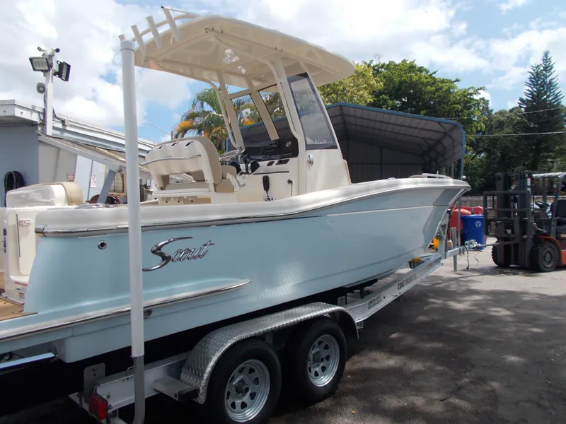 Slide: The Image of 2025 Scout 240 XSF boat on a trailer in a marina. - 2