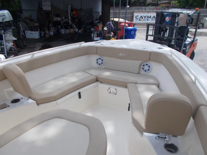 Slide: The Image of Interior seating area of 2025 Scout 240 XSF boat with beige cushions and built-in speakers. - 8