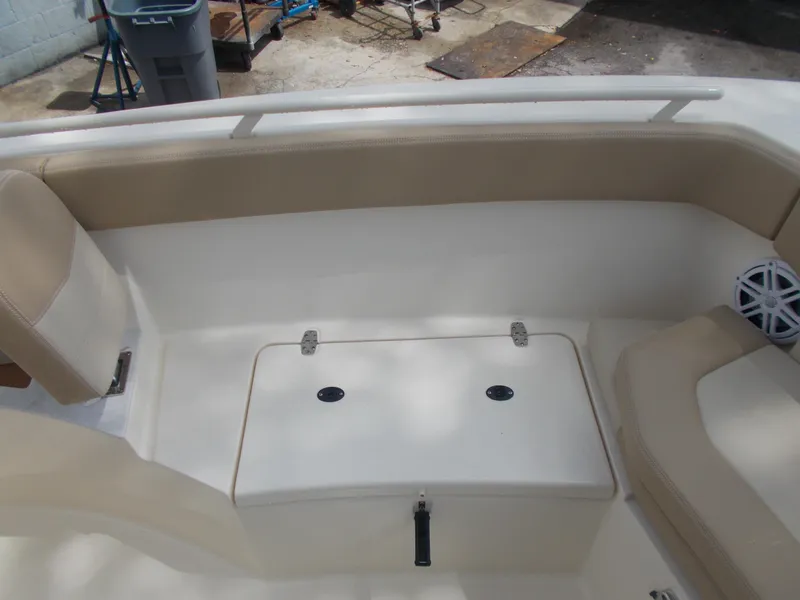 Slide: The Image of 2025 Scout 240 XSF boat interior with beige seating and storage compartment. - 9