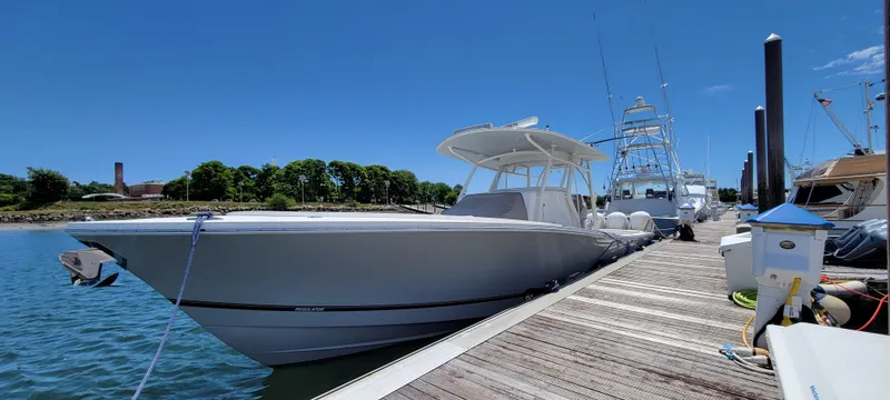 Slide: The Image of 2018 Regulator 41 Center Console boat docked at a marina on a sunny day. - 16
