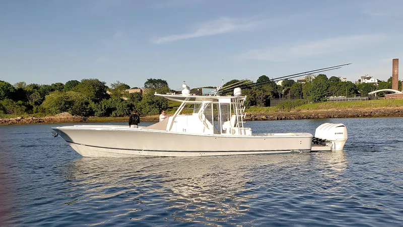 Slide: The Image of 2018 Regulator 41 Center Console boat on calm water with scenic background. - 2