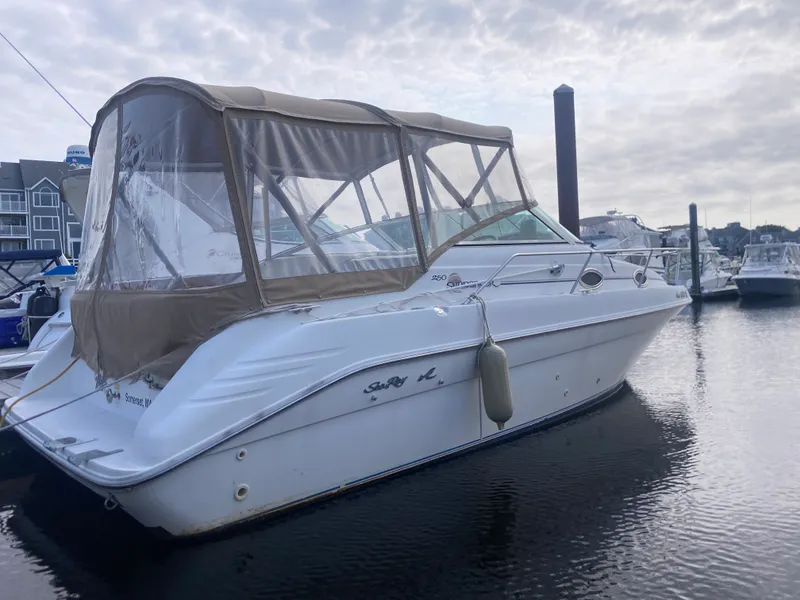 Slide: The Image of 1996 Sea Ray 250 Sundancer boat docked in marina under cloudy sky. - 2