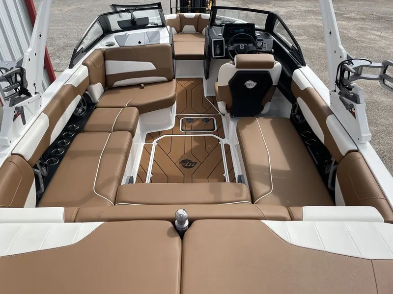 Slide: The Image of 2021 Malibu 22 LSV boat interior with tan and white seating, modern dashboard, and spacious layout. - 4