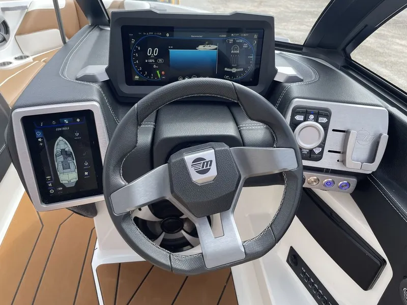 Slide: The Image of 2021 Malibu 22 LSV boat dashboard with touchscreen controls and steering wheel. - 7