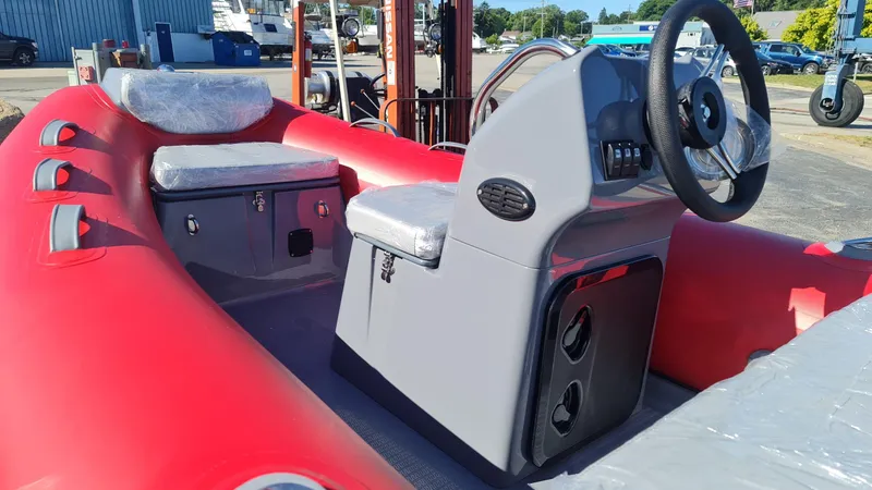 Slide: The Image of 2023 Grand Inflatables G380EF boat interior with red and gray seating and steering console. - 12