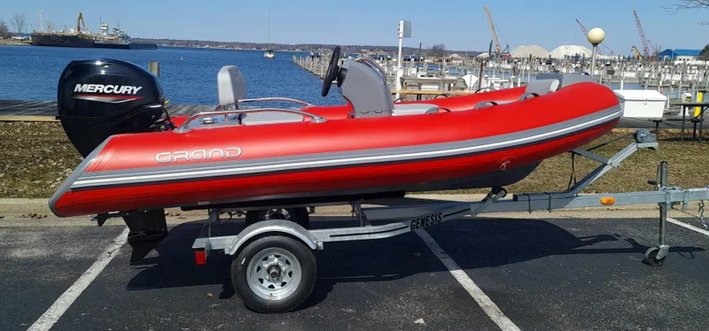 Slide: The Image of 2023 Grand Inflatables G380EF red boat on trailer with Mercury outboard motor. - 1