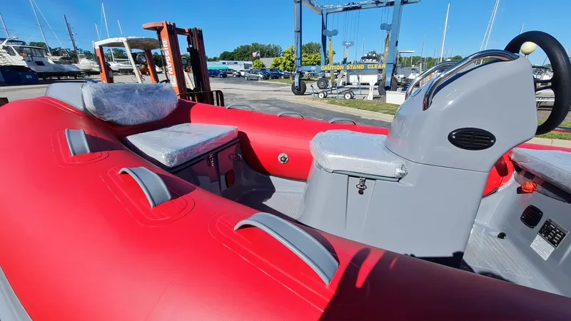 Slide: The Image of 2023 Grand Inflatables G380EF boat with red and gray interior, docked at a marina. - 15