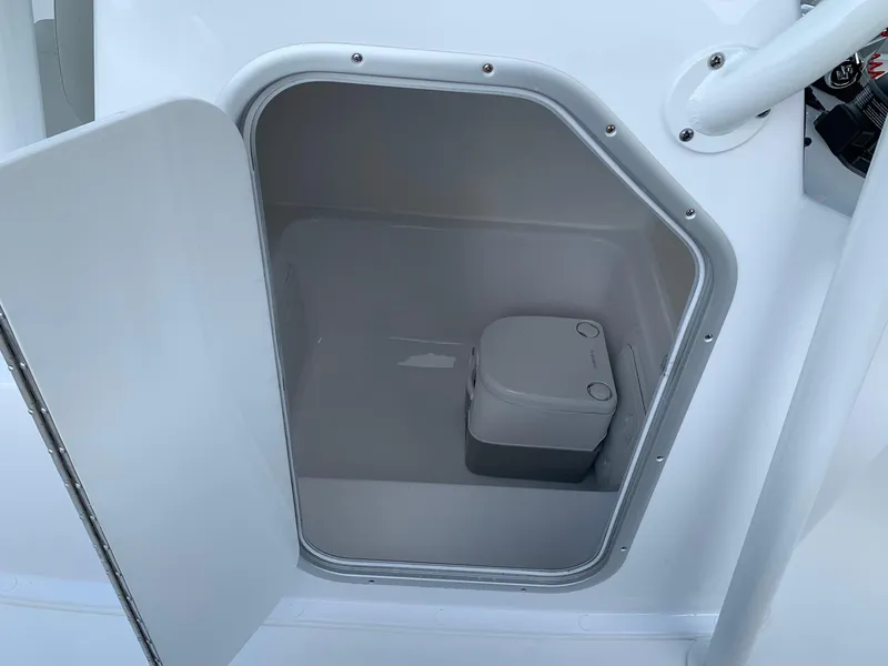 Slide: The Image of 2024 Cape Horn 24 XS boat interior storage compartment with portable toilet. - 11