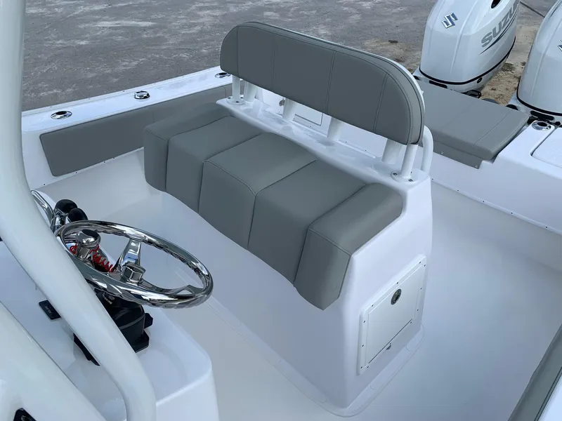 Slide: The Image of 2024 Cape Horn 24 XS boat interior with gray cushioned seating and steering wheel. - 12