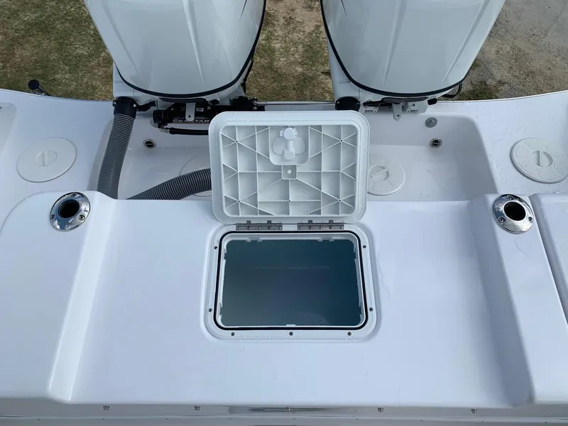 Slide: The Image of 2024 Cape Horn 24 XS boat stern with open hatch and twin engines. - 20